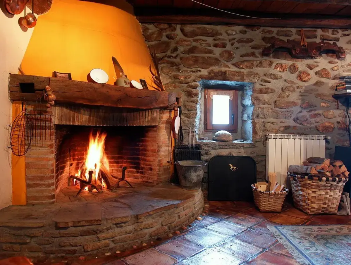 Interior de casa rural con chimenea encendida en Teruel